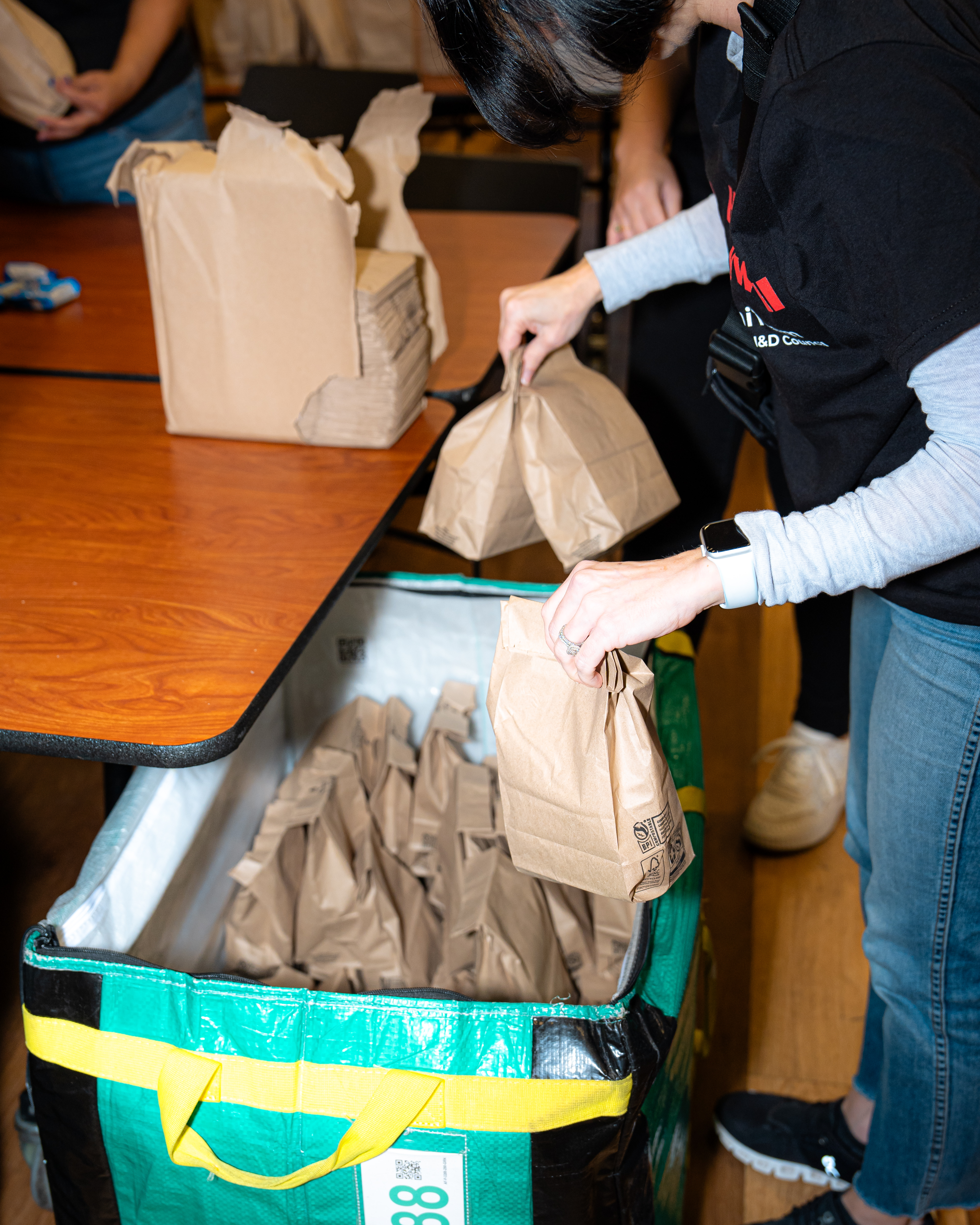 Volunteer packing up sack lunches
