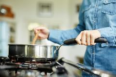 Woman cooking with natural gas on stove top