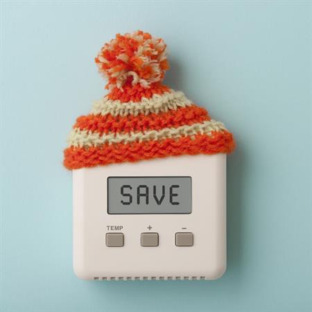 Thermostat on a blue wall with a winter hat 