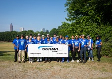 Employees holding SCANA banner with Piedmont Park in the background